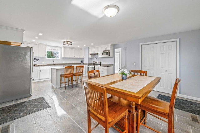 dining room with recessed lighting and baseboards