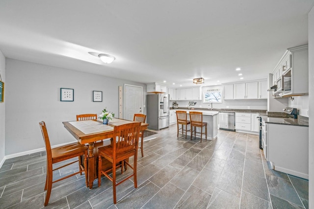 dining room with recessed lighting and baseboards