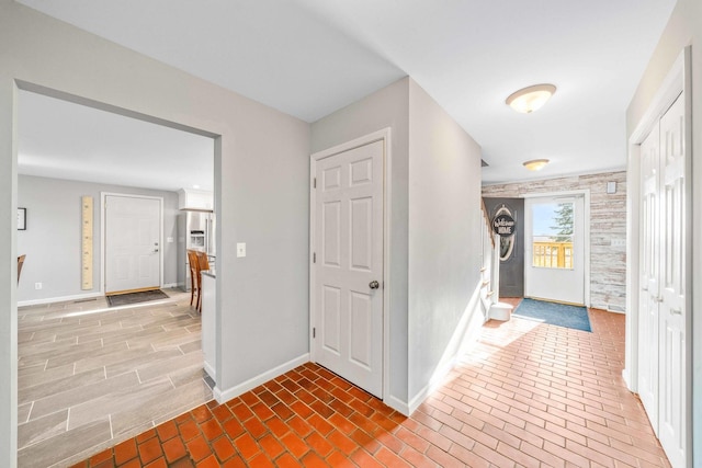 hall with brick floor and baseboards