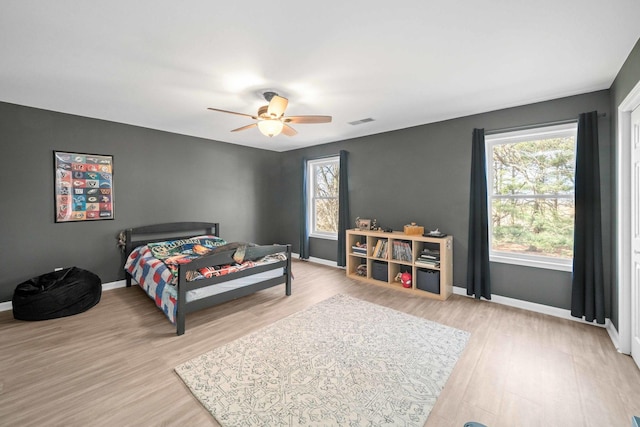 bedroom featuring visible vents, baseboards, and wood finished floors