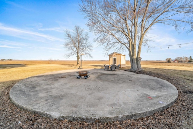 view of yard featuring a storage unit, a fire pit, and an outdoor structure