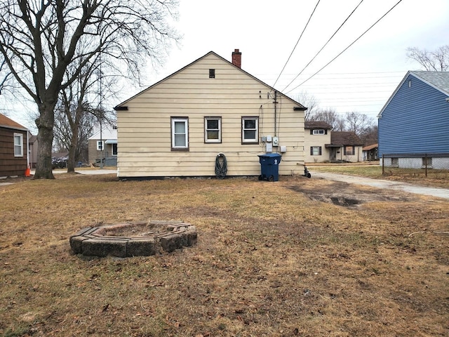 back of property with a lawn and a chimney