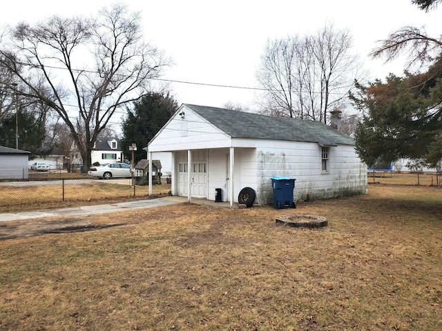 view of outdoor structure featuring an outbuilding, concrete driveway, and fence