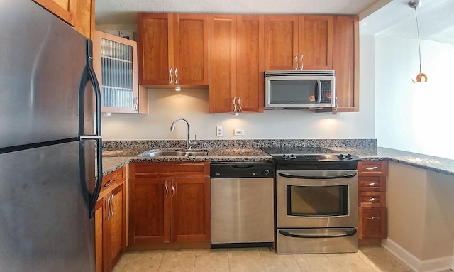 kitchen with a sink, stainless steel appliances, and brown cabinets