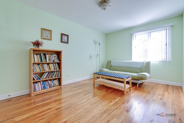 living area featuring baseboards and wood finished floors