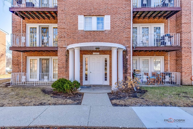 view of exterior entry featuring french doors and brick siding