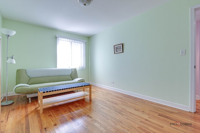 living area with light wood-style flooring and baseboards