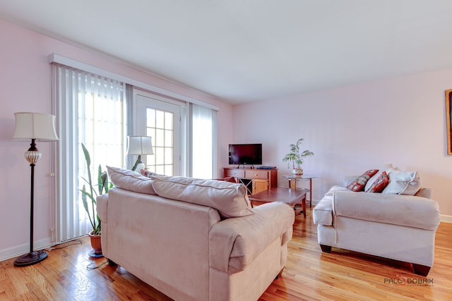 living area with baseboards and light wood finished floors