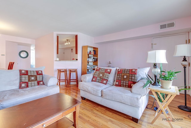 living area with visible vents and wood finished floors