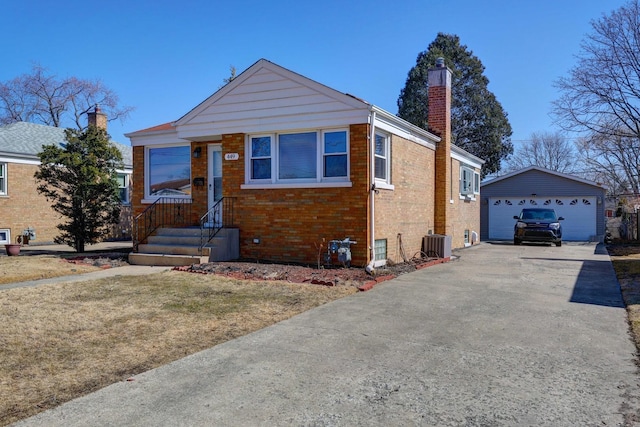 view of front of property featuring an outbuilding, a garage, brick siding, central AC unit, and a chimney