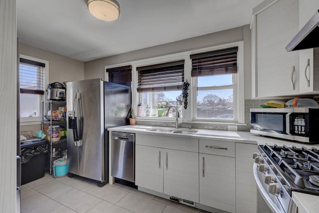 kitchen featuring a sink, stainless steel appliances, plenty of natural light, and light countertops