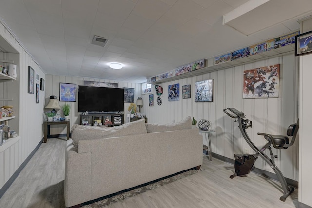 living room with visible vents, baseboards, and wood finished floors