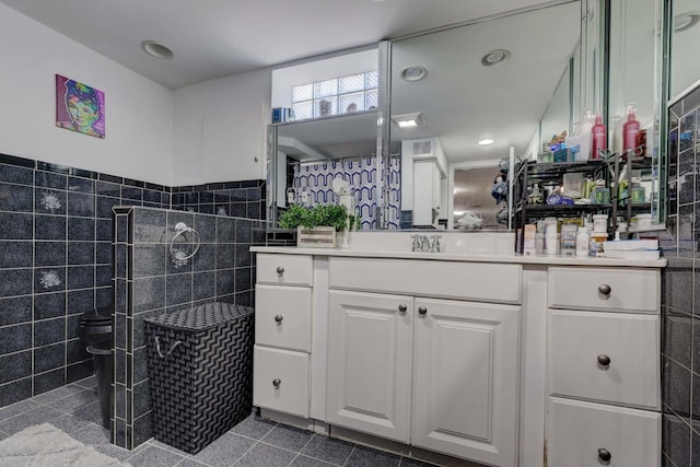 full bath with tiled shower, recessed lighting, tile walls, and vanity