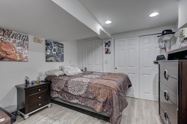 bedroom with recessed lighting, a closet, and light wood-style flooring