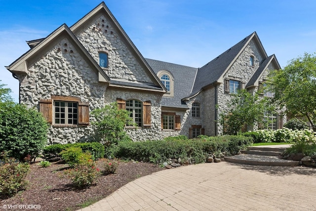 french provincial home with stone siding