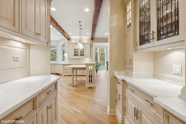 kitchen with light stone counters, glass insert cabinets, light wood-style floors, beamed ceiling, and decorative light fixtures