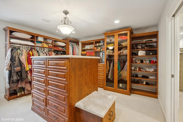 walk in closet with light carpet