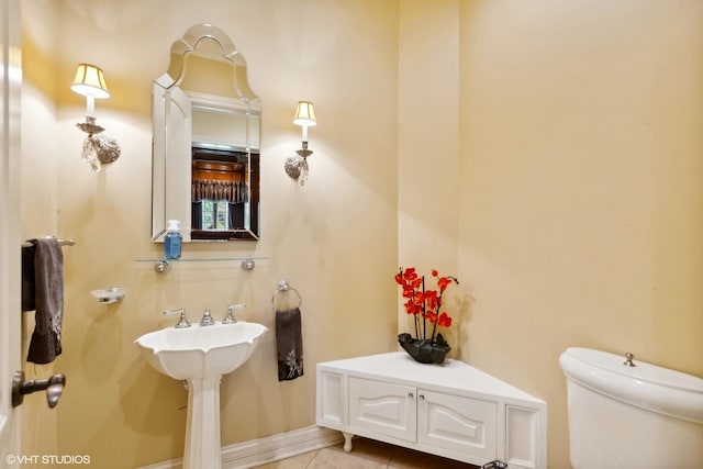 bathroom featuring tile patterned floors, baseboards, and toilet