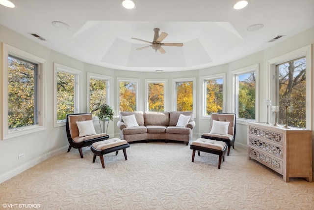 sunroom with a tray ceiling, visible vents, and ceiling fan