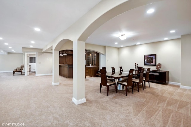 dining space with light carpet, recessed lighting, arched walkways, and baseboards