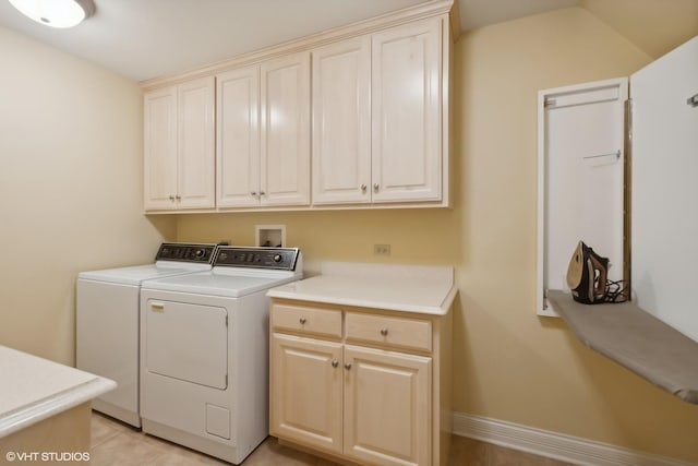 laundry area with separate washer and dryer, cabinet space, and baseboards