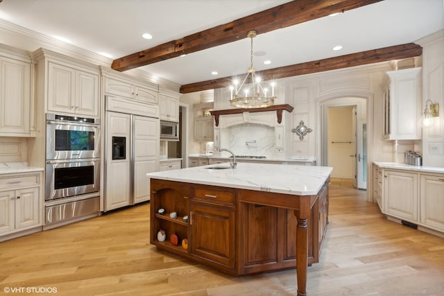 kitchen featuring beam ceiling, light wood-style flooring, a sink, built in appliances, and a warming drawer