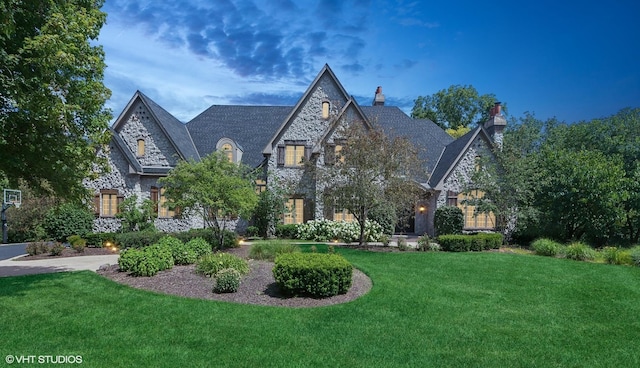 view of front of home with a front yard and stone siding