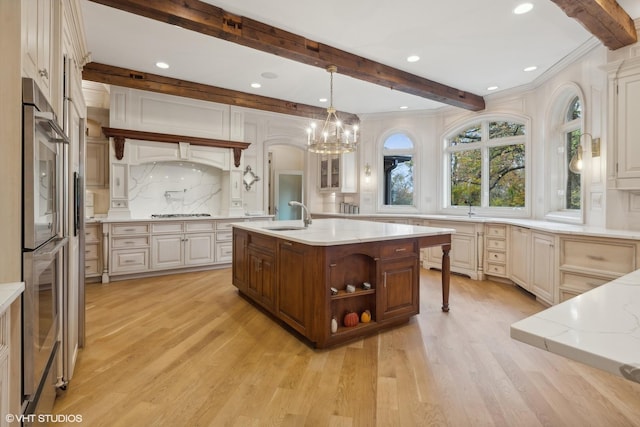 kitchen with beam ceiling, backsplash, light wood-type flooring, and a sink