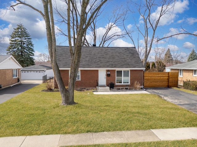 new england style home with brick siding, a front yard, an outdoor structure, and fence