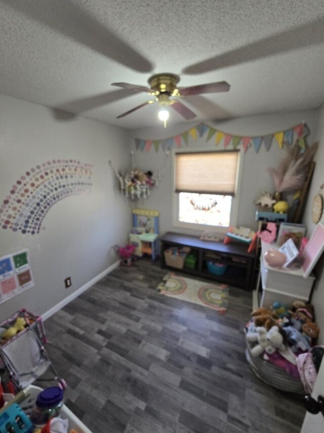 playroom with a textured ceiling, wood finished floors, baseboards, and ceiling fan