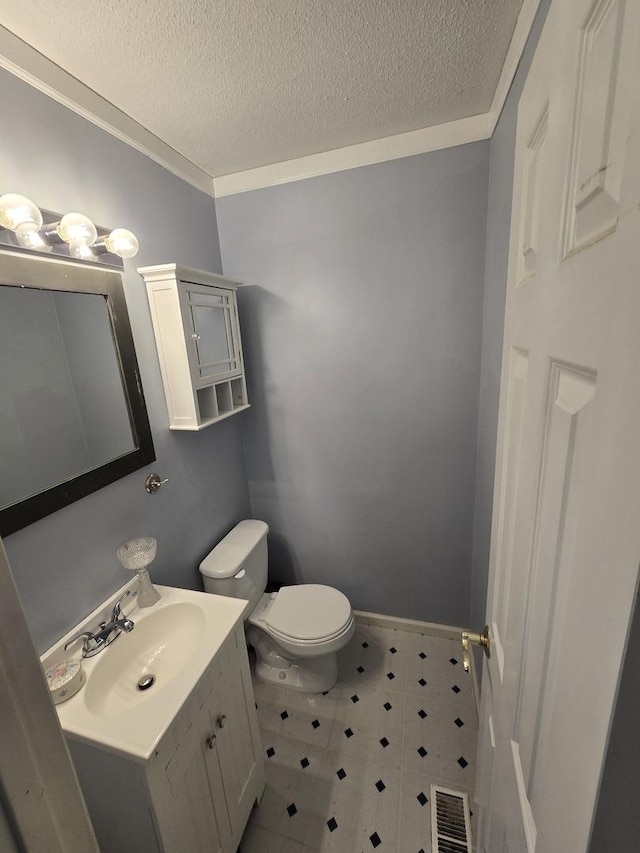 bathroom with visible vents, baseboards, toilet, vanity, and a textured ceiling