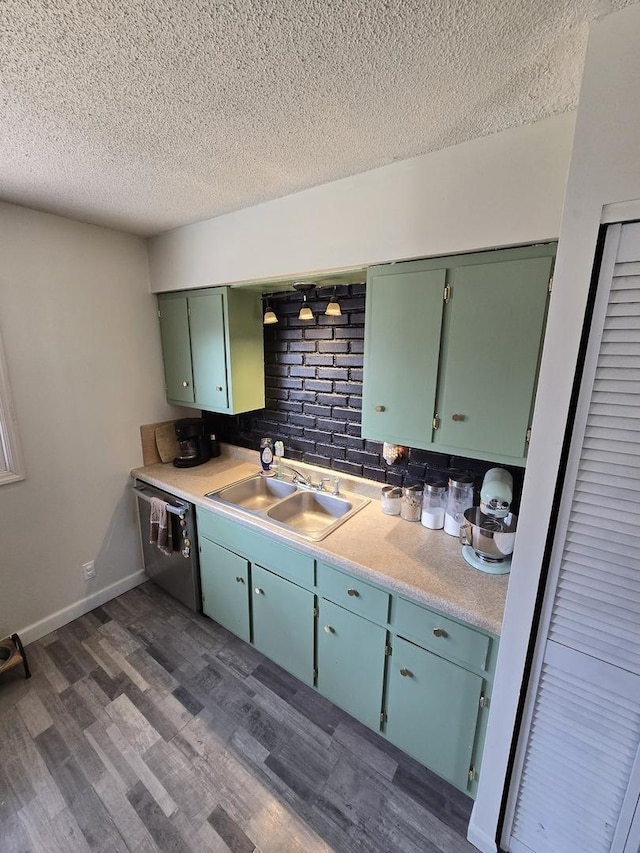 kitchen featuring dark wood-type flooring, dishwasher, light countertops, a textured ceiling, and a sink