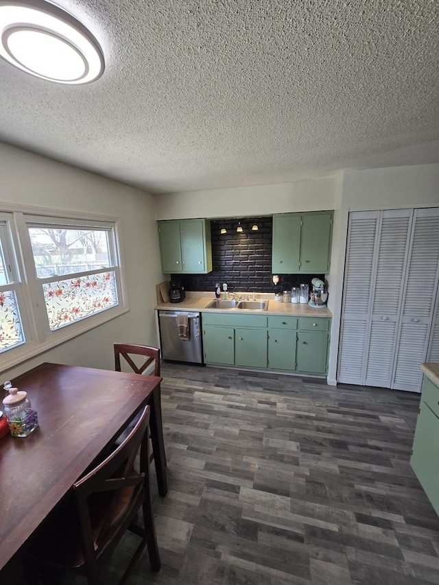 kitchen featuring dishwasher, light countertops, a sink, and green cabinetry