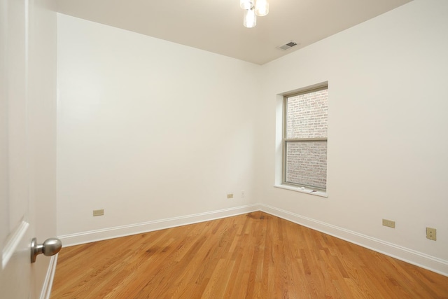 unfurnished room with visible vents, light wood-type flooring, and baseboards