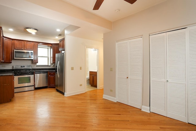 kitchen featuring dark countertops, light wood finished floors, baseboards, recessed lighting, and stainless steel appliances