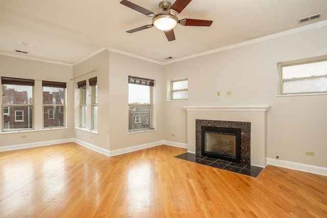 unfurnished living room featuring wood finished floors, crown molding, a fireplace, and baseboards