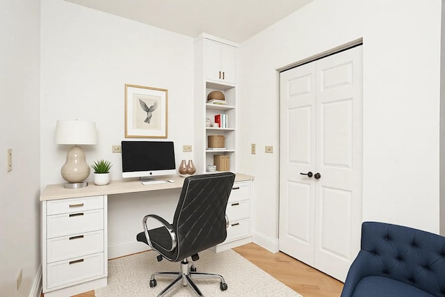 office area featuring light wood-type flooring and baseboards