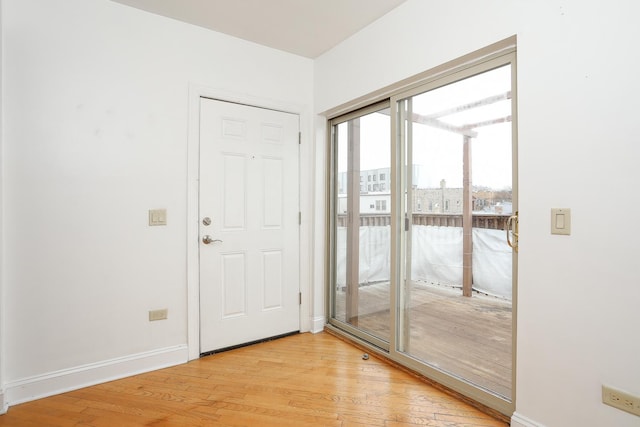 doorway featuring light wood-type flooring and baseboards