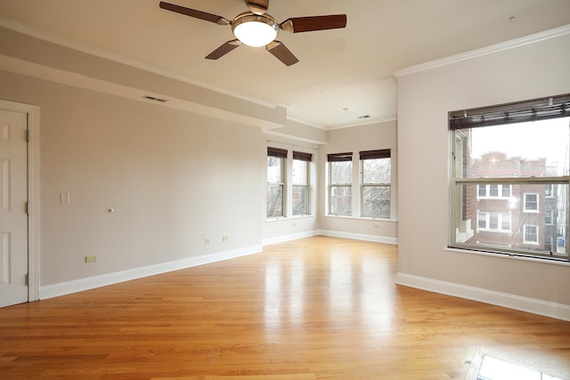 empty room featuring visible vents, a ceiling fan, crown molding, light wood finished floors, and baseboards