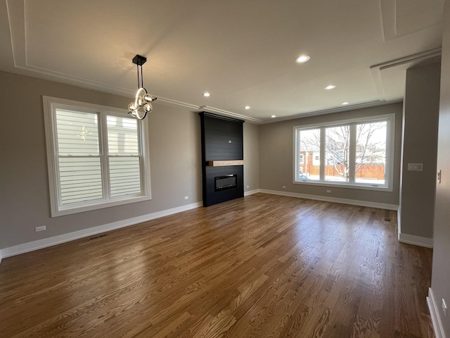 unfurnished living room with visible vents, baseboards, dark wood-type flooring, and a fireplace