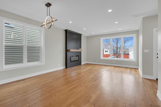 unfurnished living room with baseboards, an inviting chandelier, a fireplace, recessed lighting, and light wood-style floors