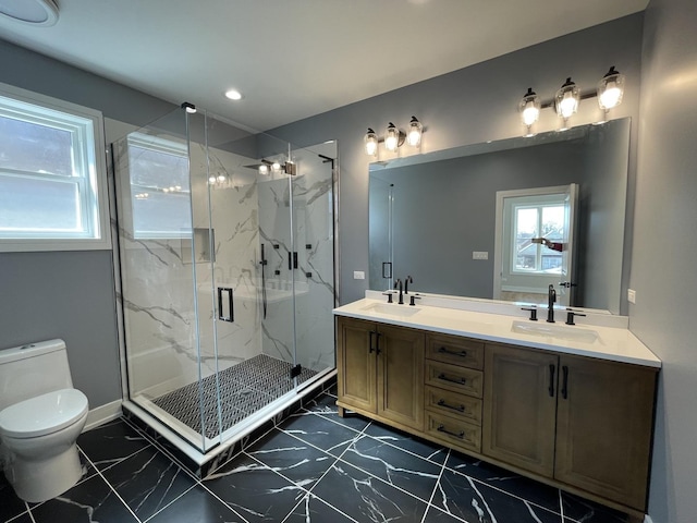 full bath featuring a sink, toilet, marble finish floor, and double vanity