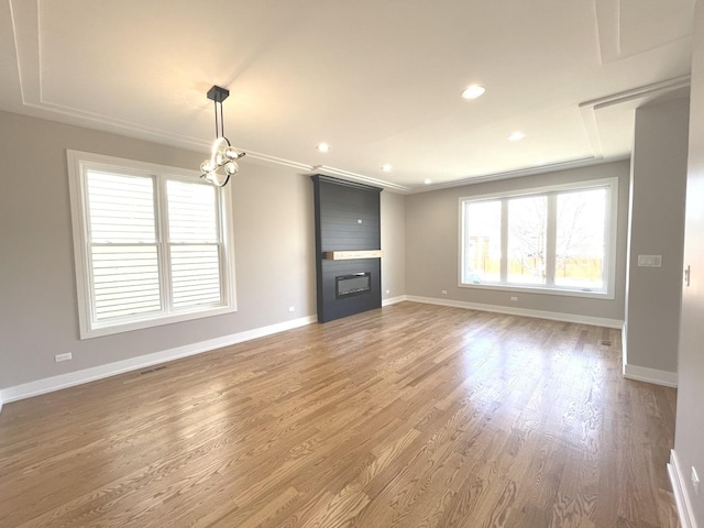 unfurnished living room with visible vents, a large fireplace, baseboards, recessed lighting, and light wood-style floors