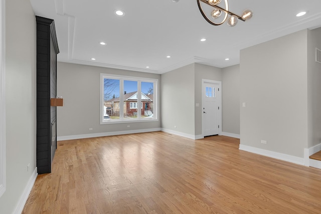 unfurnished living room with recessed lighting, baseboards, a notable chandelier, and light wood finished floors