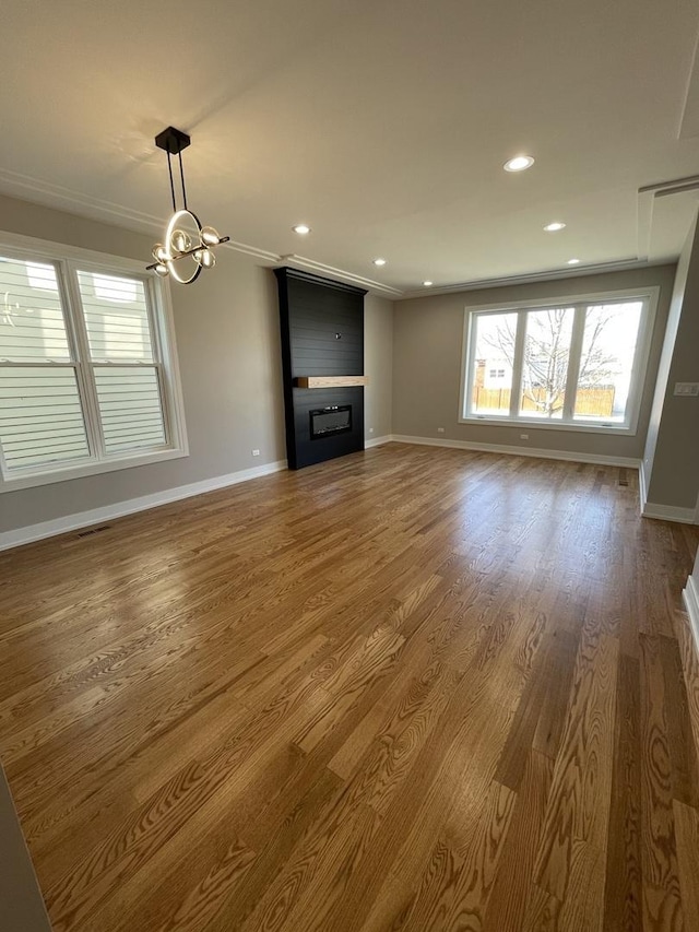 unfurnished living room featuring recessed lighting, baseboards, wood finished floors, and a fireplace