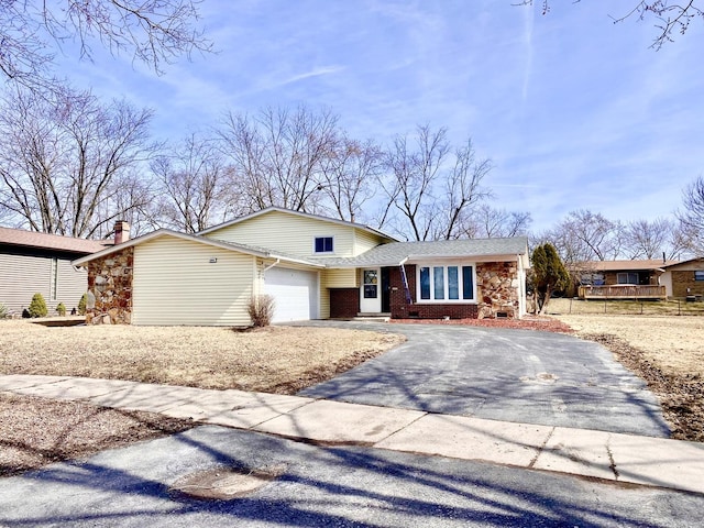 view of front of property featuring brick siding, driveway, and a garage