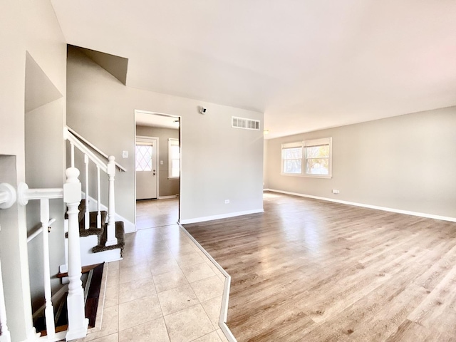 interior space with a wealth of natural light, visible vents, baseboards, and stairs