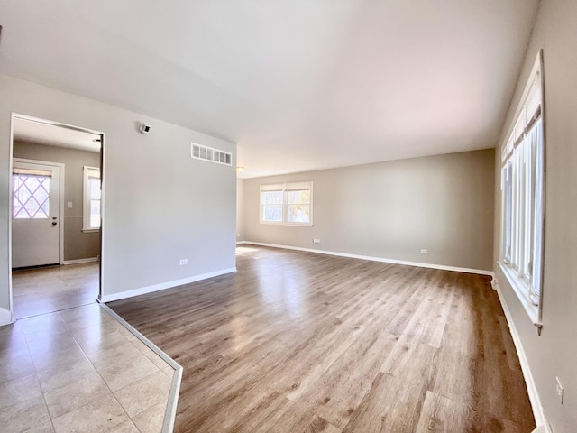 spare room with visible vents, baseboards, and wood finished floors