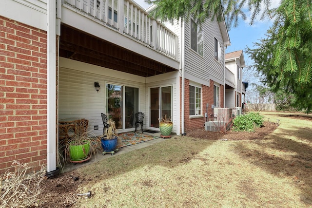 view of side of home featuring a balcony and brick siding