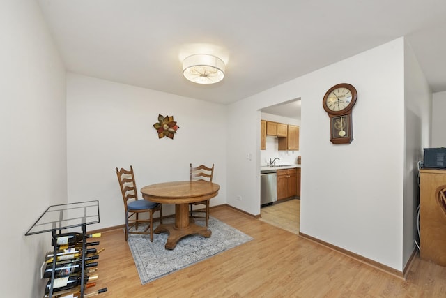 dining area with baseboards and light wood-style floors